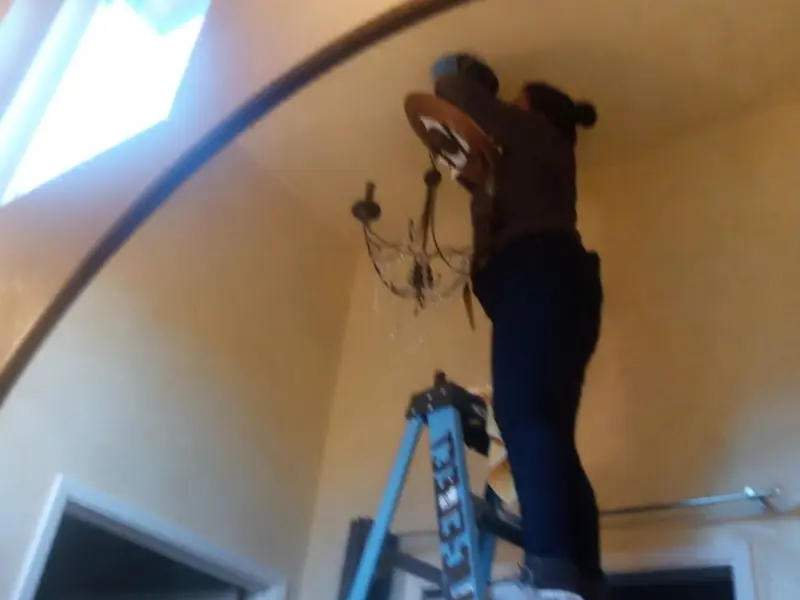 Electrician installing a chandelier in a Bucyrus residence